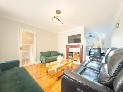 a living room with a couch and a table at House - sleeps 7 private garden & parking in Basildon