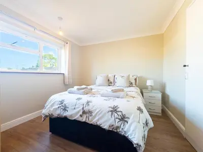 a bedroom with a bed and a window at House - sleeps 7 private garden & parking in Basildon