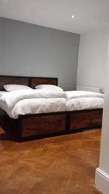 two beds in a room with wooden floors at Number 5 in Harwich