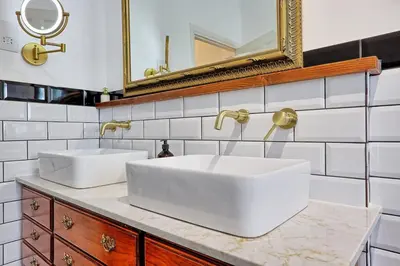 a bathroom with two white sinks and a mirror at Beautiful 5 bed house, relaxing garden and driveway parking 10 min to the beach in Southend-on-Sea