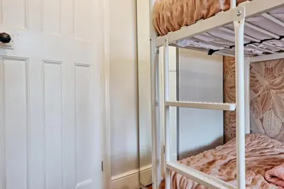 a bedroom with a bunk bed and a ladder to a bunk bed at Beautiful 5 bed house, relaxing garden and driveway parking 10 min to the beach in Southend-on-Sea