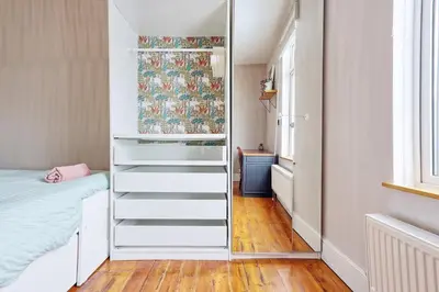 a bedroom with a closet with a bed and a window at Beautiful 5 bed house, relaxing garden and driveway parking 10 min to the beach in Southend-on-Sea