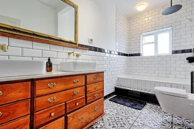 a bathroom with two sinks and a tub and a mirror at Beautiful 5 bed house, relaxing garden and driveway parking 10 min to the beach in Southend-on-Sea