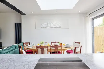 a dining room with a table and chairs at Beautiful 5 bed house, relaxing garden and driveway parking 10 min to the beach in Southend-on-Sea