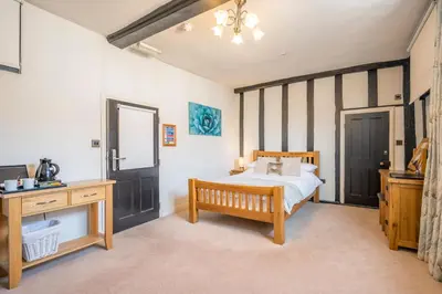 a bedroom with a bed and a table and a desk at Cotton Room, The Merchant House, Ipswich in Ipswich