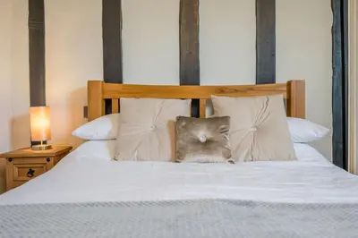 a cat sitting on top of a bed with pillows at Cotton Room, The Merchant House, Ipswich in Ipswich