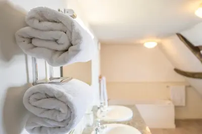 a bathroom with towels hanging on a towel rack at Merchant Quarters, The Merchant House, Ipswich in Ipswich