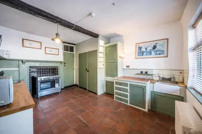 a kitchen with green cabinets and a tile floor at Merchant Quarters, The Merchant House, Ipswich in Ipswich