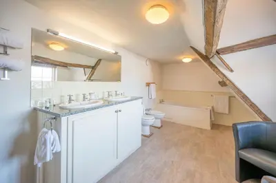 a bathroom with two sinks and a toilet and a mirror at Merchant Quarters, The Merchant House, Ipswich in Ipswich