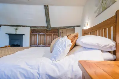 a large bed with white sheets and pillows at Merchant Quarters, The Merchant House, Ipswich in Ipswich