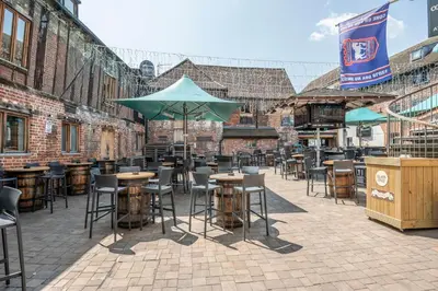 a patio with tables and chairs and an umbrella at Silk Room, The Merchant House, Ipswich in Ipswich