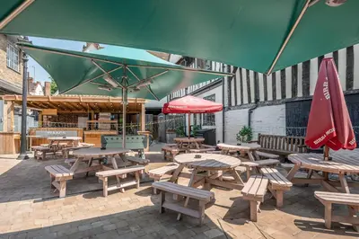 a group of picnic tables and benches with umbrellas at Wool Room, Merchant House, Ipswich in Ipswich