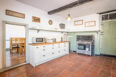 a kitchen with white cabinets and a microwave at Wool Room, Merchant House, Ipswich in Ipswich