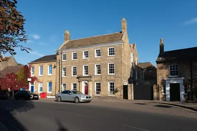 a car parked in front of a large brick building at Poets 24 in Ely