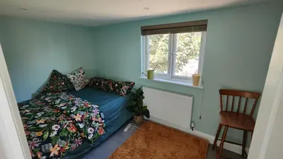 a bedroom with a bed and a window and a chair at Crystalsspace in Braintree