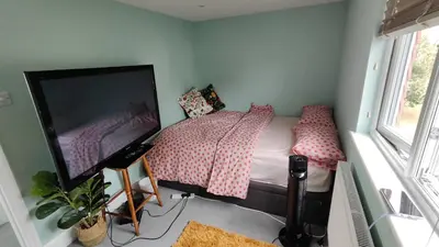 a bedroom with a bed and a flat screen tv at Crystalsspace in Braintree