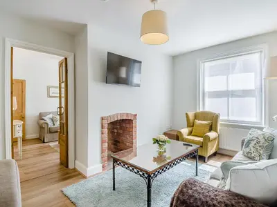 a living room with a couch and a fireplace at Courtyards in Diss