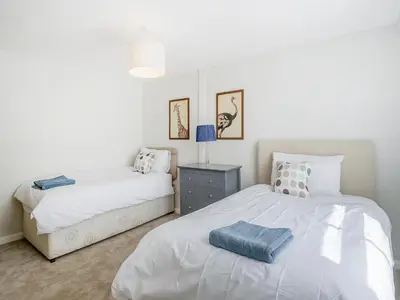 a bedroom with two beds and a nightstand and a bed sidx sidx sidx sidx at Courtyards in Diss