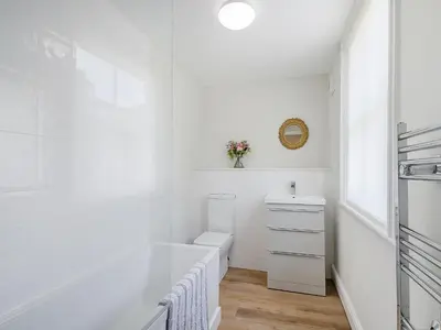 a white bathroom with a sink and a toilet at Courtyards in Diss
