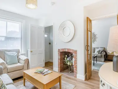 a living room with a fireplace and a couch at Courtyards in Diss