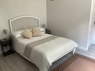 a bedroom with a white bed with two pillows at The Meadow Garden Guest Room in Newmarket