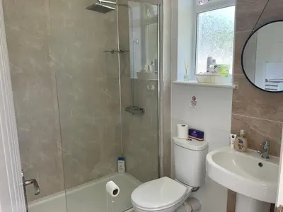 a bathroom with a shower and a toilet and a sink at The Meadow Garden Guest Room in Newmarket