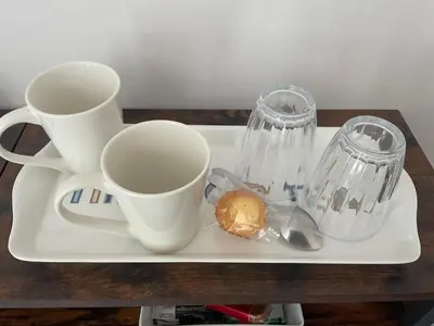 a tray with two cups and a sandwich on it at The Meadow Garden Guest Room in Newmarket
