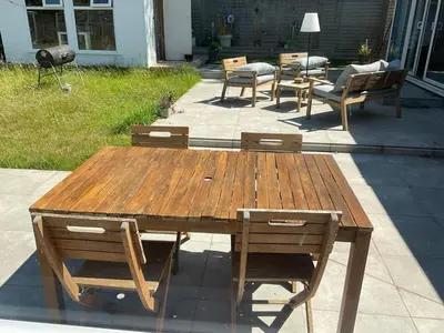 a wooden table and chairs on a patio at The Meadow Garden Guest Room in Newmarket