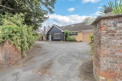 a house with a brick wall and a driveway at Entire spacious house in BSE in Bury Saint Edmunds