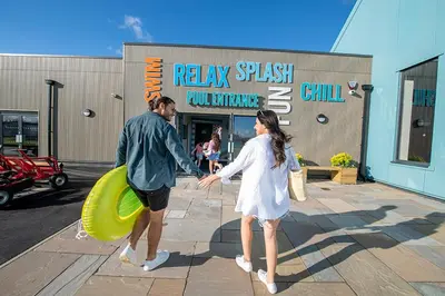 a man and a woman holding hands in front of a building at Your Seaside Escape at St Osyth Modern caravan with decking and wifi and parking Nr to Clacton on Sea in Saint Osyth