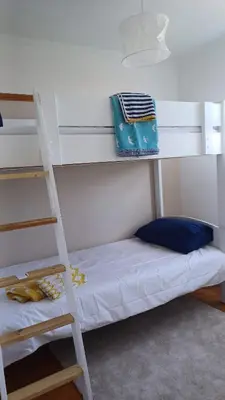 a white bunk bed with a ladder and a pillow at Beachside Terrace in Dovercourt