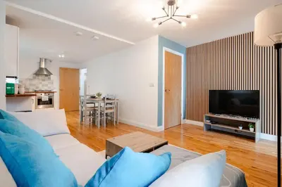 a living room with a couch and a tv at Stunning 2 Bedroom Flat with Charming Patio in Cambridge