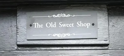 a sign for the old sweet shop on a wall at The Old Sweet Shop in Harwich