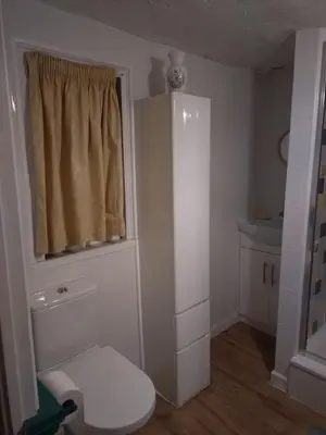a small bathroom with a toilet and a window at The Old Sweet Shop in Harwich