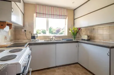 a kitchen with a stove and a sink and a window at 18 Linden Road - sleeps 5 - Less than a mile from the Aldeburgh Beach and a Vibrant High Street in Aldeburgh