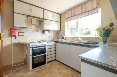 a kitchen with a stove and a sink and a window at 18 Linden Road - sleeps 5 - Less than a mile from the Aldeburgh Beach and a Vibrant High Street in Aldeburgh