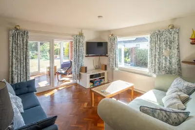 a living room with blue couches and a tv at 18 Linden Road - sleeps 5 - Less than a mile from the Aldeburgh Beach and a Vibrant High Street in Aldeburgh