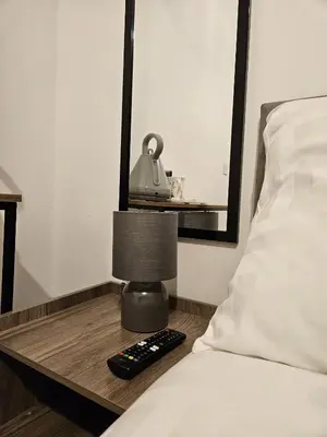 a bed with a lamp on a night stand next to a bed at Apartment Royston Center in Royston