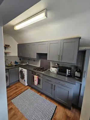 a kitchen with gray cabinets and a washer and dryer at Apartment Royston Center in Royston