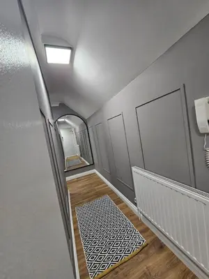 an empty hallway with a staircase with a mirror at Apartment Royston Center in Royston