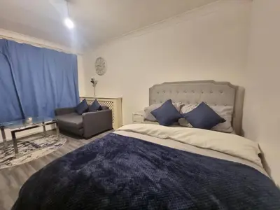 a bedroom with a large bed and a chair at Budget Room Stevenage Town Centre in Stevenage