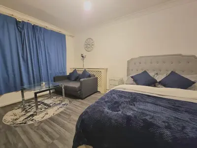 a bedroom with a bed and a couch and a table at Budget Room Stevenage Town Centre in Stevenage