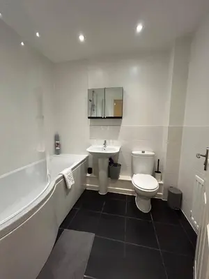 a bathroom with a sink and a toilet and a bath tub at Stunning 2BR house in Colchester in Colchester