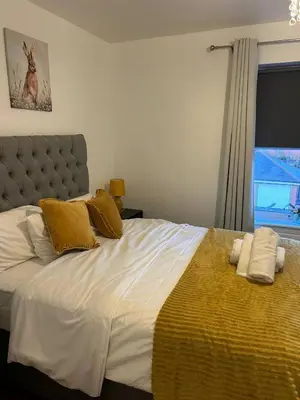 a bedroom with a large bed with yellow and white pillows at Stunning 2BR house in Colchester in Colchester