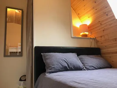a bedroom with a bed with a wooden ceiling at Muntjac Cabin in Elmswell