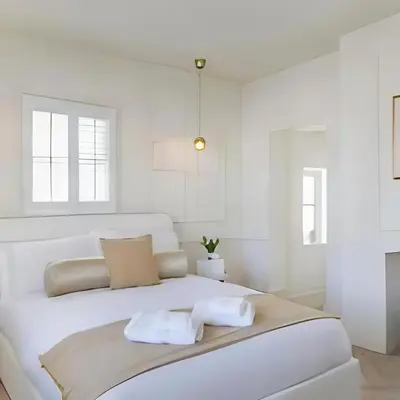 a white bedroom with a large white bed with two towels at Stunning house in the heart of Leigh-On-Sea in Leigh-on-Sea