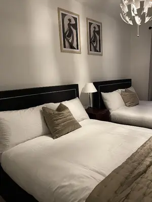 a bedroom with two beds and a chandelier at The Crimsons, with free parking, Harlow in Harlow