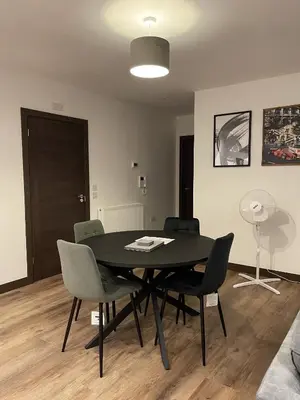 a black dining room table with chairs and a fan at The Crimsons, with free parking, Harlow in Harlow