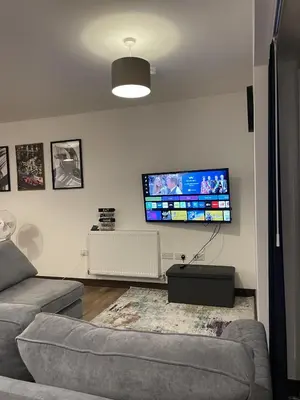 a living room with a couch and a flat screen tv at The Crimsons, with free parking, Harlow in Harlow
