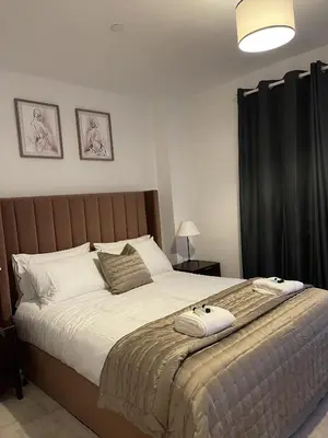 a bedroom with a large bed with two towels on it at The Crimsons, with free parking, Harlow in Harlow